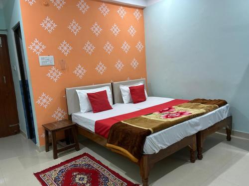 a bedroom with a bed with red and white pillows at Kedar Guest House Ayodhya in Ayodhya