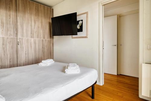 a bedroom with a bed and a tv on the wall at GiaxTower Gym Spa & Pool Bright Space in Milan