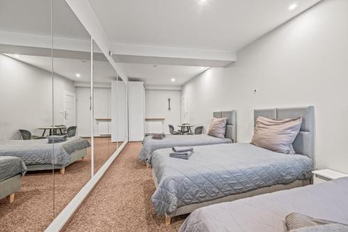 een slaapkamer met 3 bedden en een spiegel bij Apartamenty Centrum in Rybnik