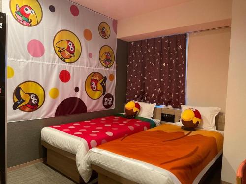 a bedroom with two beds and a wall with stickers at Henn na Hotel Tokyo Nishikasai in Tokyo