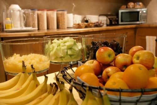 un montón de plátanos y manzanas y otras frutas en un mostrador en R&R Inn & Suites, en Camrose