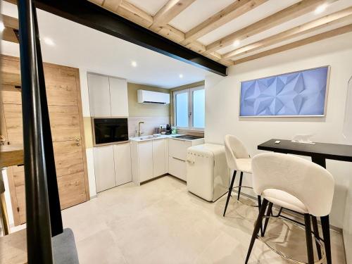 eine Küche mit weißen Schränken und einem Tisch und Stühlen in der Unterkunft Golden Prestige Serenity & Elegance in Chenôve