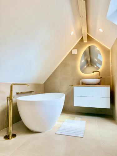 a bathroom with a large white tub and a sink at Golden Prestige Serenity & Elegance in Chenôve