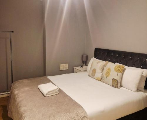 a bedroom with a large bed with white sheets and pillows at King Edward 3 bed house ideal for contractors in Darlaston