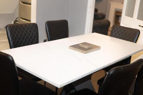 a book sitting on top of a white table with chairs at King Edward 3 bed house ideal for contractors in Darlaston