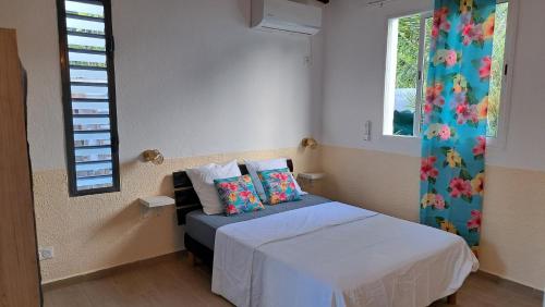 a small bedroom with a bed and a window at Fleur de Lys 2 in Petit-Bourg