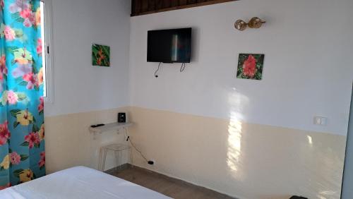 a room with a bed and a tv on the wall at Fleur de Lys 2 in Petit-Bourg