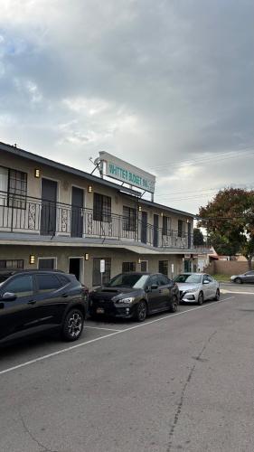 a hotel with cars parked in a parking lot at Budget inn Whittier in Whittier