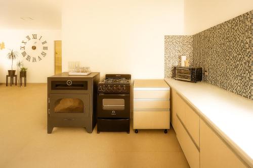 Departamento LUNA NUEVA في سانتا كلارا ديل مار: مطبخ مع فرن وطاولة مع ساعة