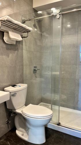 a bathroom with a toilet and a glass shower at Budget inn Whittier in Whittier