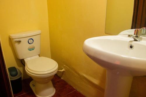a bathroom with a white toilet and a sink at Casa rústica Pumayalli in Urubamba