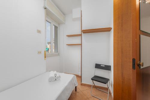 Habitación con cama blanca y silla en Easy Parking - Air Conditioning - Balcony - Quiet, en Cinisello Balsamo