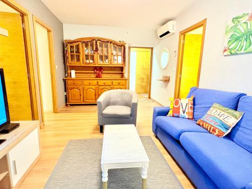 a living room with a blue couch and a chair at Casa CAMPELO- Playas de Pinténs - CANGAS-HIO- Ría de Aldán in Cangas de Morrazo