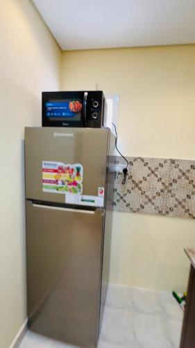 a refrigerator with a television on top of it at Quiet area studio, fully furnished and ready now u in Abu Dhabi