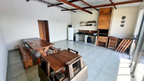 a living room with a table and a kitchen at Edícula Roma - Casa de hóspedes in Campo Mourão