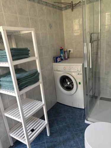 a bathroom with a washing machine and a washer at Villa Hanna in Villa Faraldi