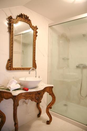a bathroom with a sink and a mirror on a table at Casa Manuel Espregueira e Oliveira in Viana do Castelo
