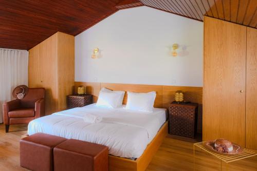una camera da letto con un letto grande e una sedia di Aldeia da Graça a Guimarães