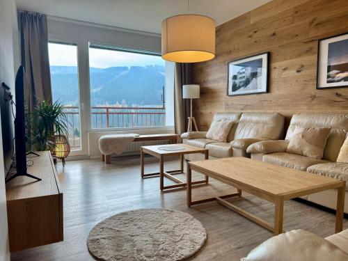 a living room with a couch and a table at Family Apartment 104 in Špindlerův Mlýn