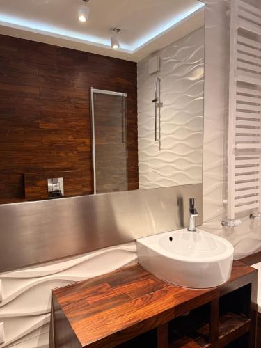 Un baño con un lavabo blanco y un espejo. en Home4You, en Cracovia
