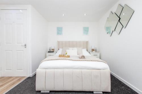 - une chambre blanche avec un lit blanc et un miroir dans l'établissement Modern Cozy Flat 6 mins to City Parking & WiFi, à Killingbeck