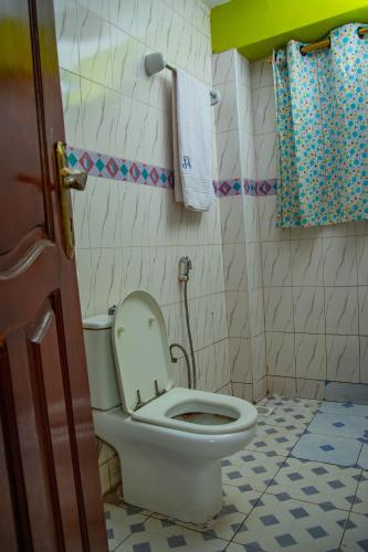 a bathroom with a toilet with the lid up at Primera Hotel Kampala in Kampala