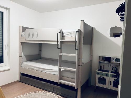 a bunk bed in a room with a kitchen at Cocon family in Strasbourg