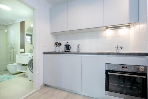 a white kitchen with a sink and a stove at Studio Apartment "Dida" with Free Private Parking in Solin