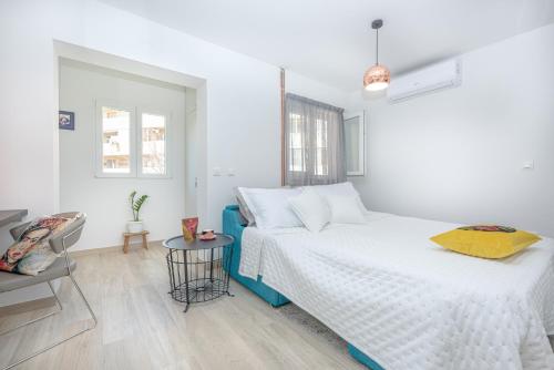 a white bedroom with a bed and a table at Studio Apartment "Dida" with Free Private Parking in Solin