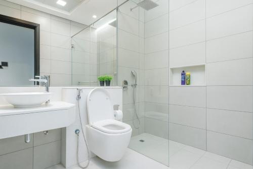 a white bathroom with a toilet and a sink at New Large 2BR Apt Sleeps 10 Adults with Pool Gym Parking and Wifi in Dubai