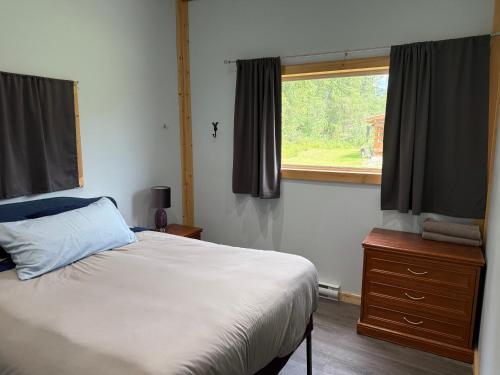 ein Schlafzimmer mit einem Bett und einem Fenster in der Unterkunft Pine Marten Wilderness Cabin in Golden