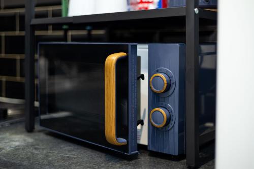 un four à micro-ondes avec la porte ouverte sur une étagère dans l'établissement Modern Cozy Flat 6 mins to City Parking & WiFi, à Killingbeck
