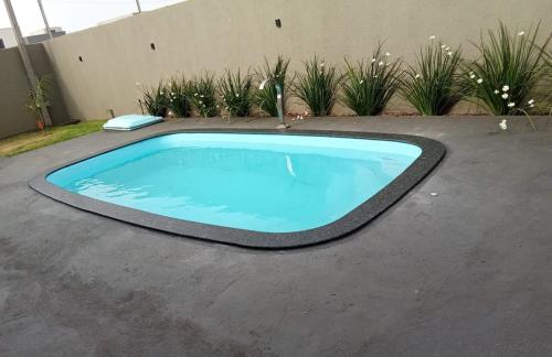 a large blue swimming pool in a driveway at Edícula Roma - Casa de hóspedes in Campo Mourão