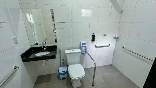 un bagno bianco con un water e un lavandino di Flat & Hotel Executive a Confresa