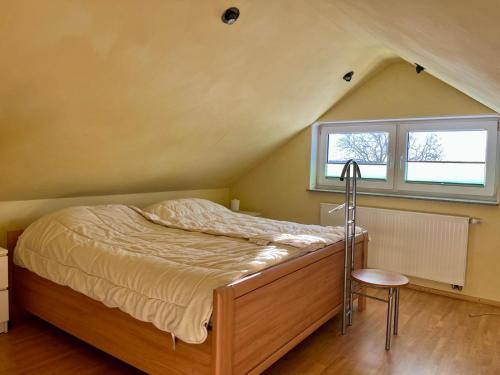 ein Schlafzimmer mit einem Bett, einem Fenster und einem Stuhl in der Unterkunft Fernblick Giershagen in Marsberg