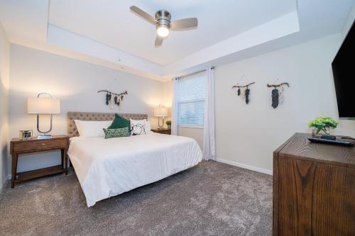 基西米3131-108FV STOREY LAKE, CONDO 3/2 LAKE VIEW的一间卧室，里面有一张床和一个吊扇