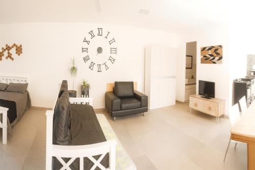 Departamento LUNA NUEVA في سانتا كلارا ديل مار: غرفة معيشة فيها سرير وكرسي وساعة