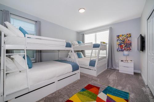 a bedroom with two bunk beds and a television at 800MO VILLA 5 BED/5 BA in Orlando