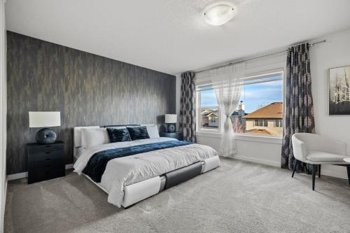a bedroom with a large bed and a window at The Copperleaf Luxury Retreat with Hot tub in Calgary