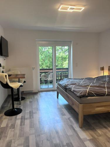 a bedroom with a bed and a desk and a balcony at Seeblickmatzelsdorf in Millstatt