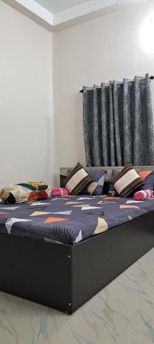 a large bed in a room with pillows on it at Diya STAYS in Rāmpur Hāt