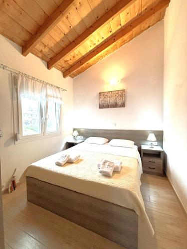 a bedroom with a large bed with towels on it at Theo Two-Bedroom Apartment in Marathias
