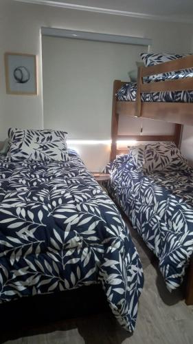 a bedroom with two beds and a bunk bed at Vive Pucón in Pucón