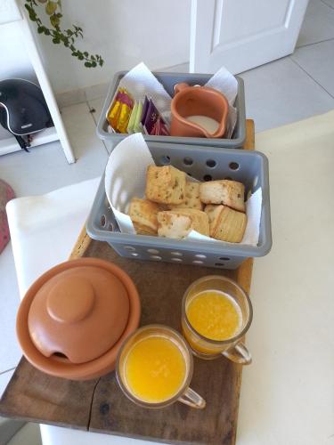 Tiny House Potrero Cba في بوتريرو دي غاراي: علبة غداء تحتوي على خبز وعصير برتقال موضوعة على طاولة