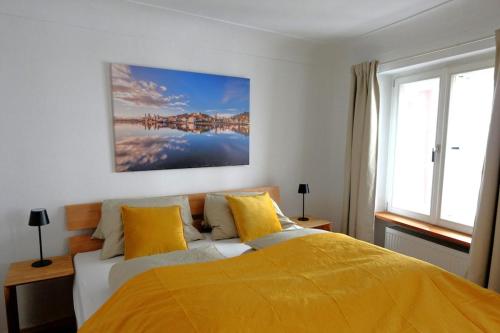 une chambre avec un lit avec une couverture jaune dans l'établissement Charming Old Town Apartment - Central and Cozy, à Passau