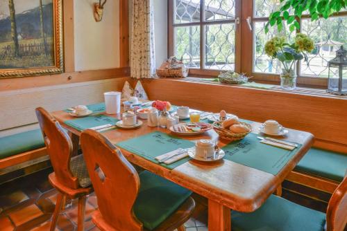 a wooden table in a room with a table with food on it at Hotel Alter Wirt in Weyarn