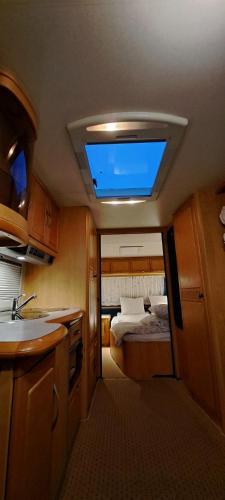 a small room with a bed and a skylight at Proboost Arctic Center Cosy Caravan in Rovaniemi