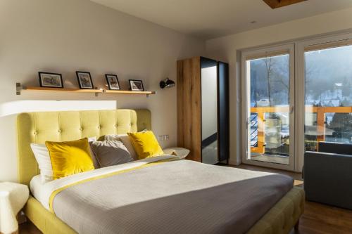 ein Schlafzimmer mit einem großen Bett mit gelben Kissen in der Unterkunft HARLEY FAMILY APARTAMENT in Muszyna