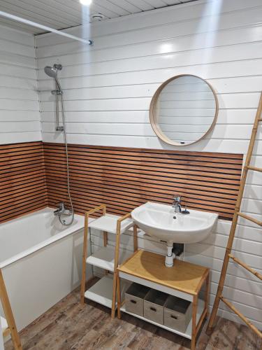 a bathroom with a sink and a mirror and a tub at Cocooning in Cerences