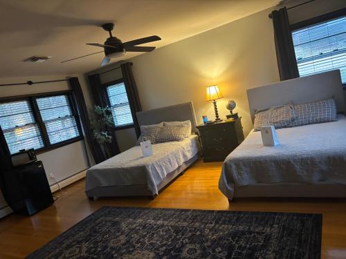a bedroom with two beds and a ceiling fan at Hotel Plantsylvania in Temple Hills